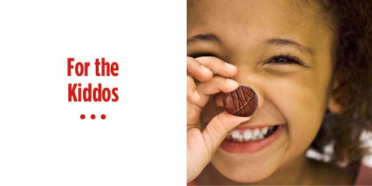 smiling girl holding piece of chocolate candy